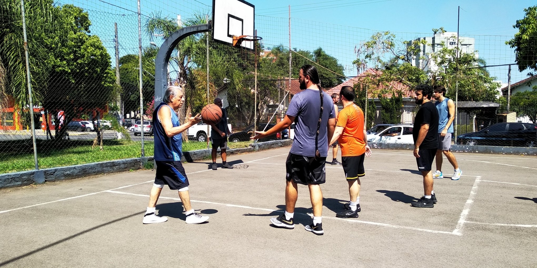 Grupo de amigos jogando basquete em uma quadra pública ao ar livre