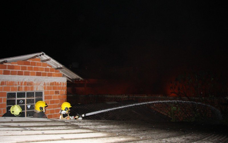 Bombeiros combatendo incÃªndio para evitar chegada das chamas Ã s casas situadas na Rua ChapecÃ³