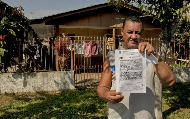 A esperada escritura está a caminho. Aladio com a certidão de posse aguarda pelo documento definitivo