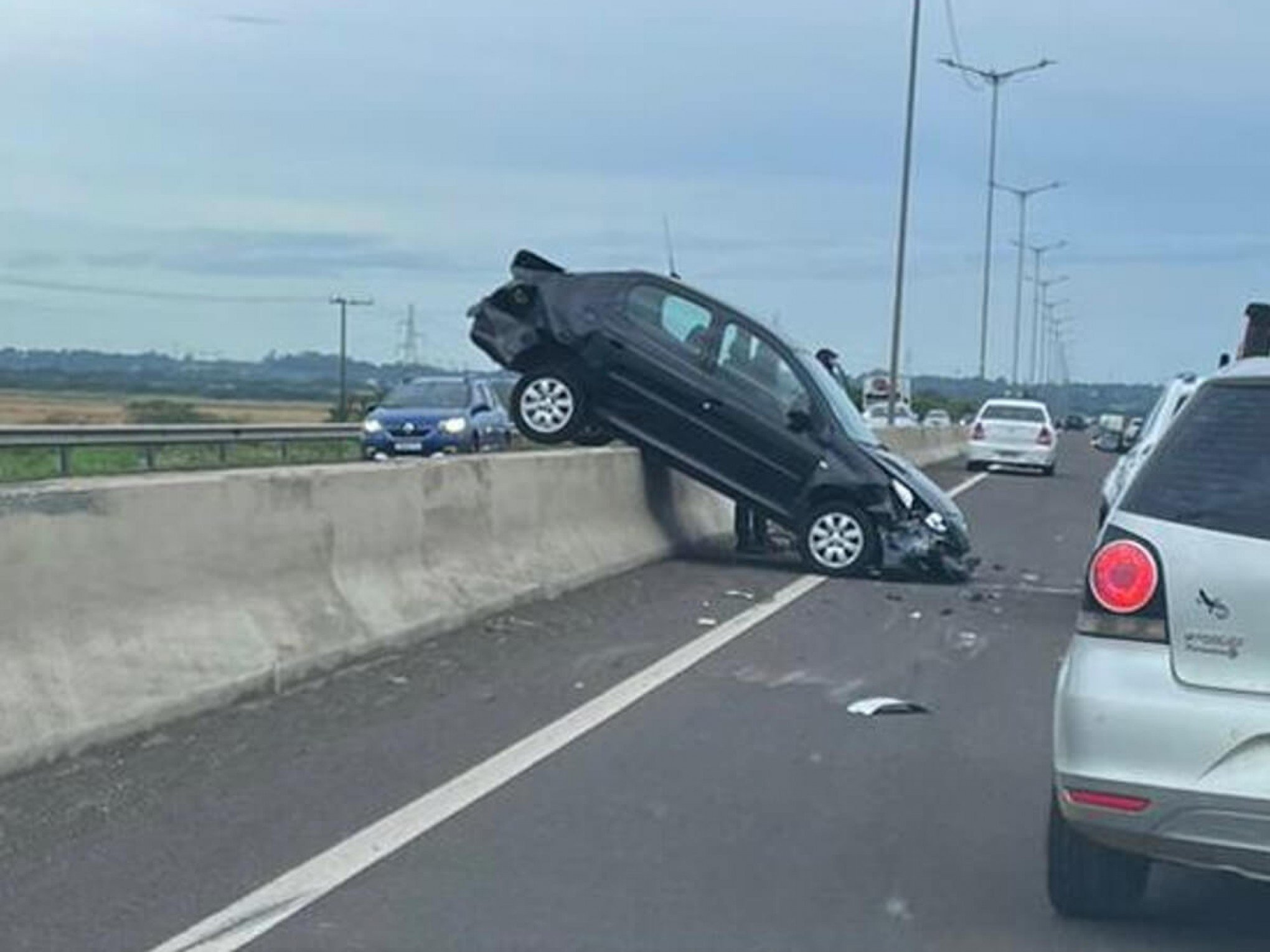 VEJA FOTO: Carro vai parar sobre mureta central em acidente de trânsito