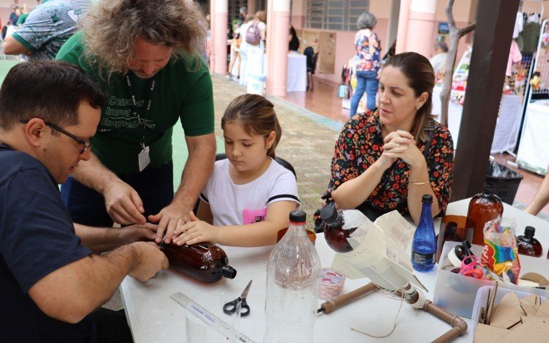 Eduardo Mariussi (e) produzindo um foguete com a filha Luíza Mariussi (meio) e a esposa Paula Tonello (direita)