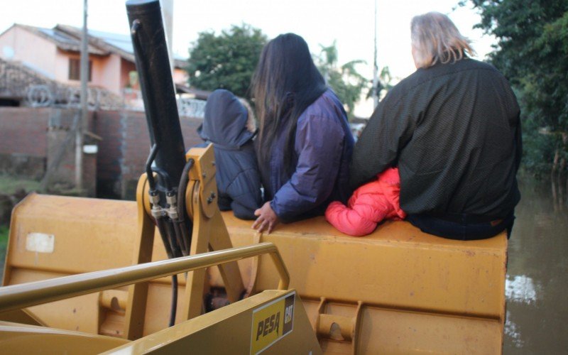 Suélen Alves (29) e os filhos, Émerson, 9, e Ágatha de 7 anos, conseguiram voltar para casa com a carona da retroescavadeira  | Jornal NH