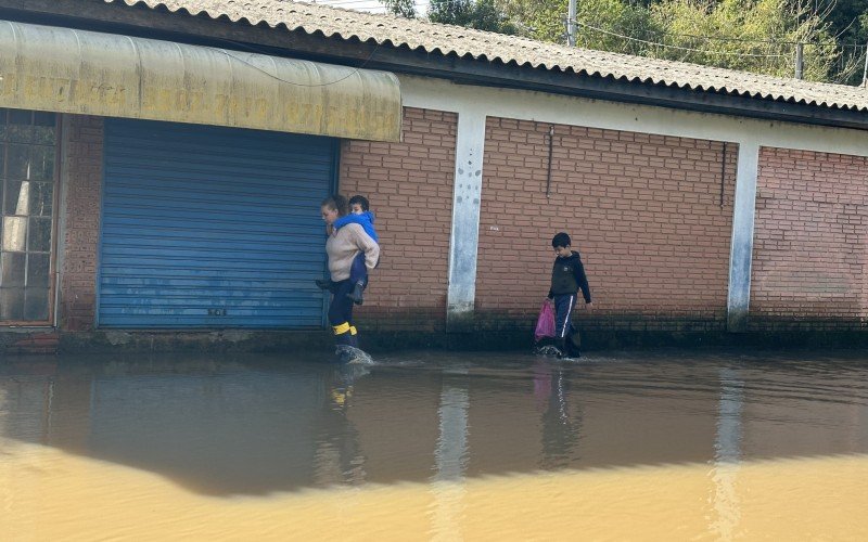 Mariane com o filho Heitor nas costas e Davi caminhando atrás  | Jornal NH