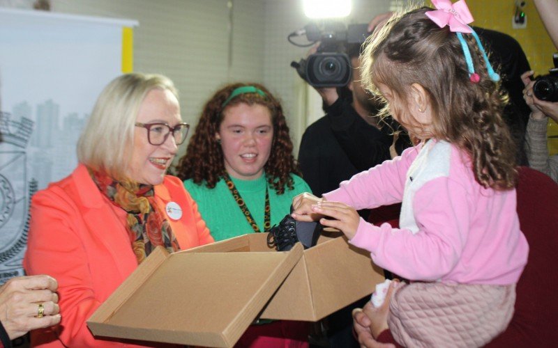 SecretÃ¡ria Arita Bergmann faz a entrega de calÃ§ado para menina