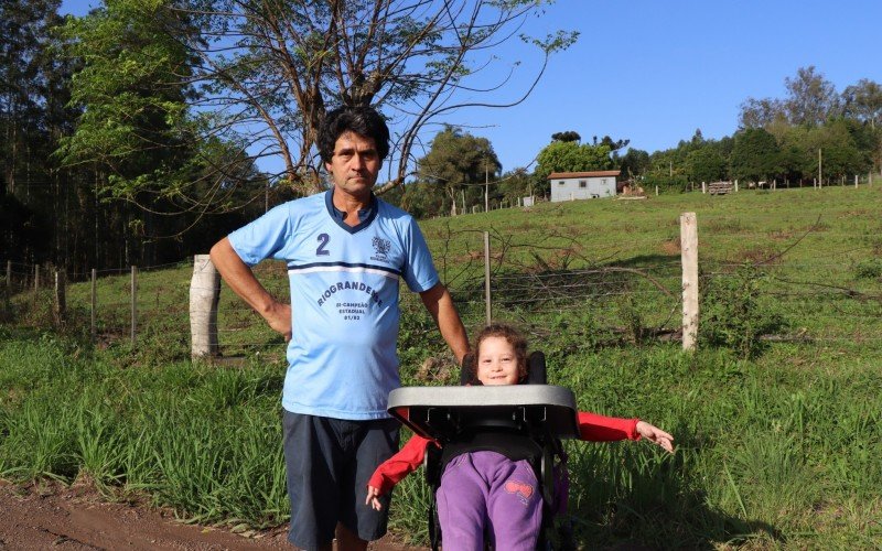 CÃ©sar Ribeiro atravessa a rodovia com a filha cadeirante