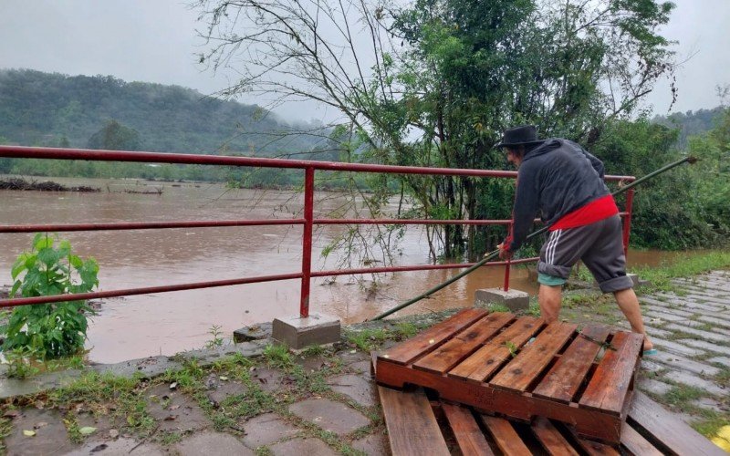 JosÃ© Valcir Carvalho da Cruz, 63 anos, ajudando por conta prÃ³pria desobstruir passam de Ã¡gua obstruÃ­da por pallets