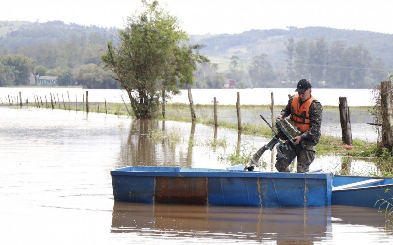 Moradores com barcos ajudam outros a saÃ­rem do bairro Porto Palmeira, em Sapiranga 