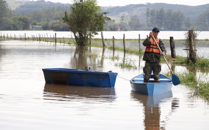 Moradores com barcos ajudam outros a saÃ­rem do bairro Porto Palmeira, em Sapiranga 