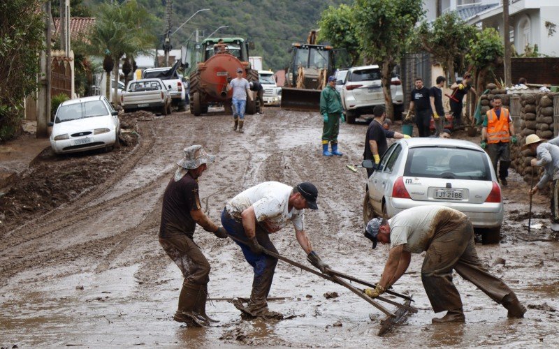 Grupo do Vale do Sinos usou rodo para tentar arrastar 
lodo de rua de MuÃ§um que fica Ã s margens do Rio Taquari