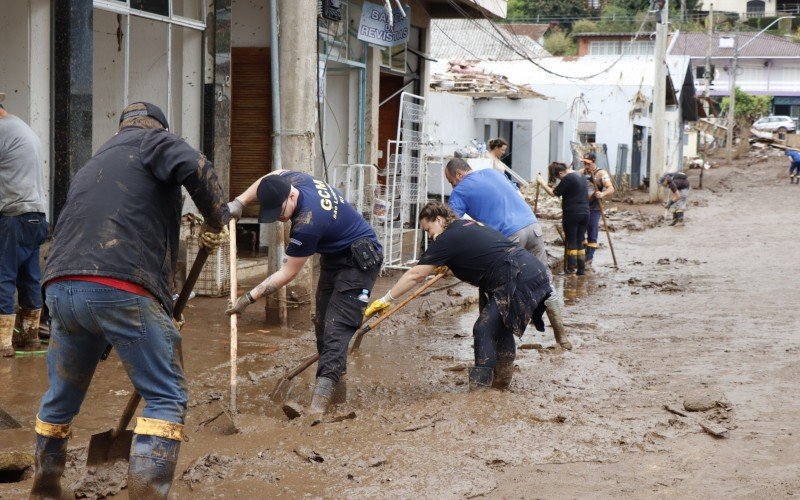 Alan Kuhn e Débora Schuh, de Dois Irmãos, empenhados com outros voluntários na limpeza de Muçum