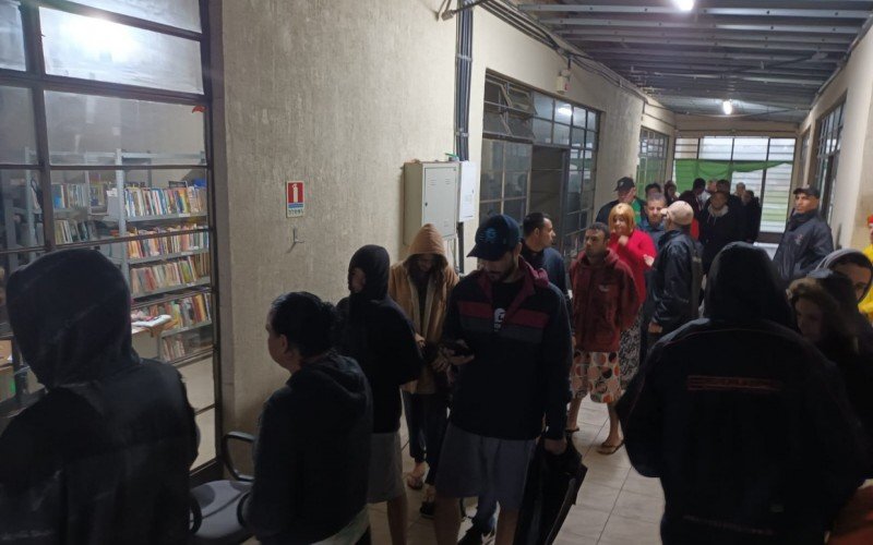 Moradores buscam lonas no bairro Guajuviras, em Canoas