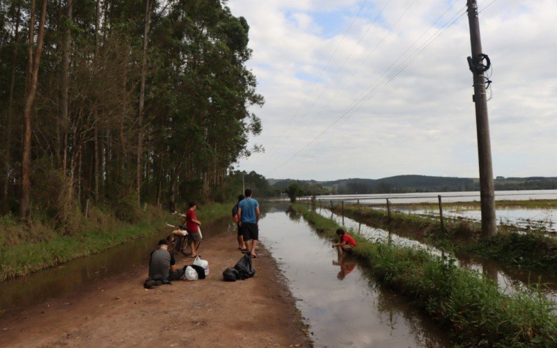 Enquanto barcos nÃ£o vÃªem, as pessoas esperam onde a Ã¡gua ainda nÃ£o chegou