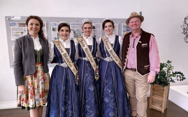 Kunst (Ã  direita) com Ana Paula (Ã  esquerda), a princesa Sofia, a rainha KÃ¡dina e a princesa Jenifer visitaram o Grupo Sinos para divulgar a festividade que mobiliza a comunidade atÃ© o final do mÃªs