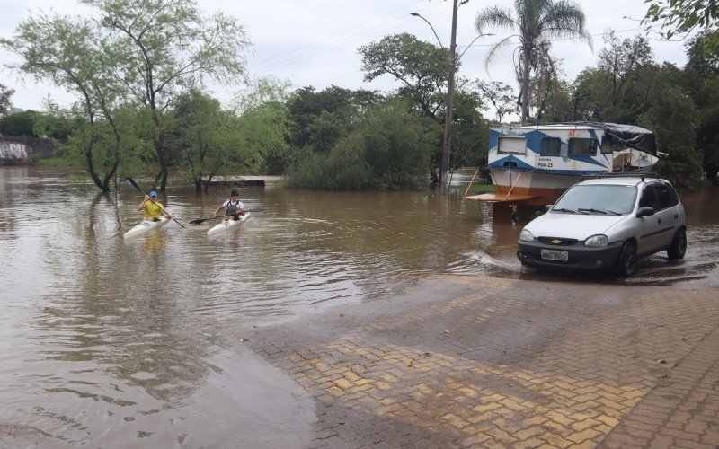 Atletas praticam canoagem em inundação da Rua da Praia