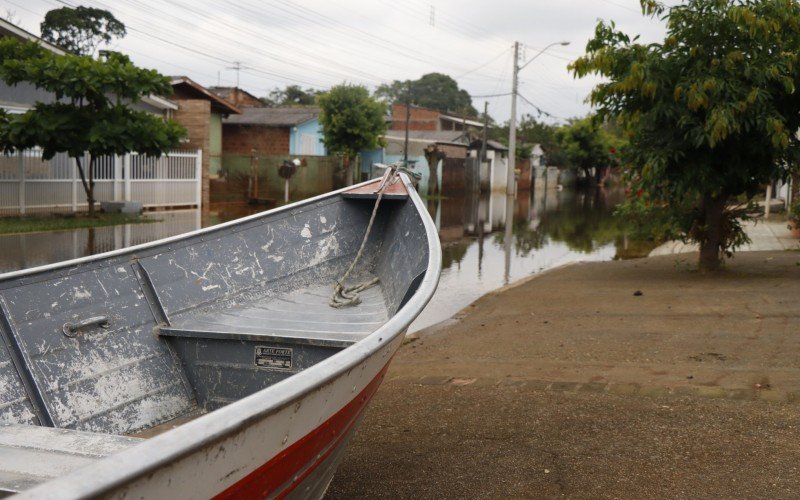 Moradores deixam barcos na calÃ§ada para que possam se locomover nas Ã¡reas alagadas do bairro