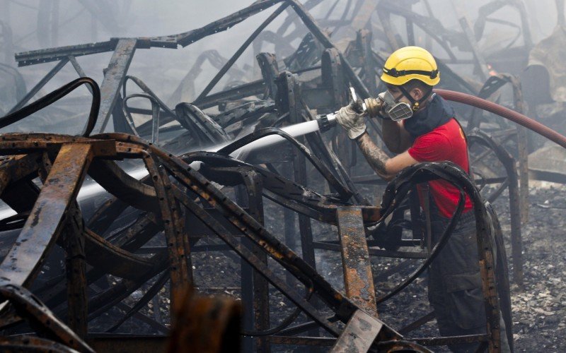 Trabalho do corpo de bombeiros em meio a montanhas de ferro retorcido e fuligem 