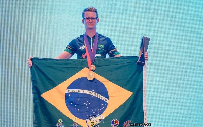 Lucas com a medalha e a bandeira do Brasil na Tailândia