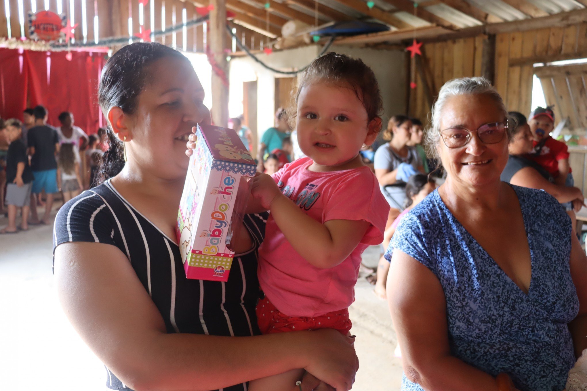 Entrega de brinquedos do projeto Melodia SolidÃ¡ria na OcupaÃ§Ã£o Steigleder - Emilli no colo da mÃ£e Fabiana e acompanhada da vÃ³, Maria Celonir