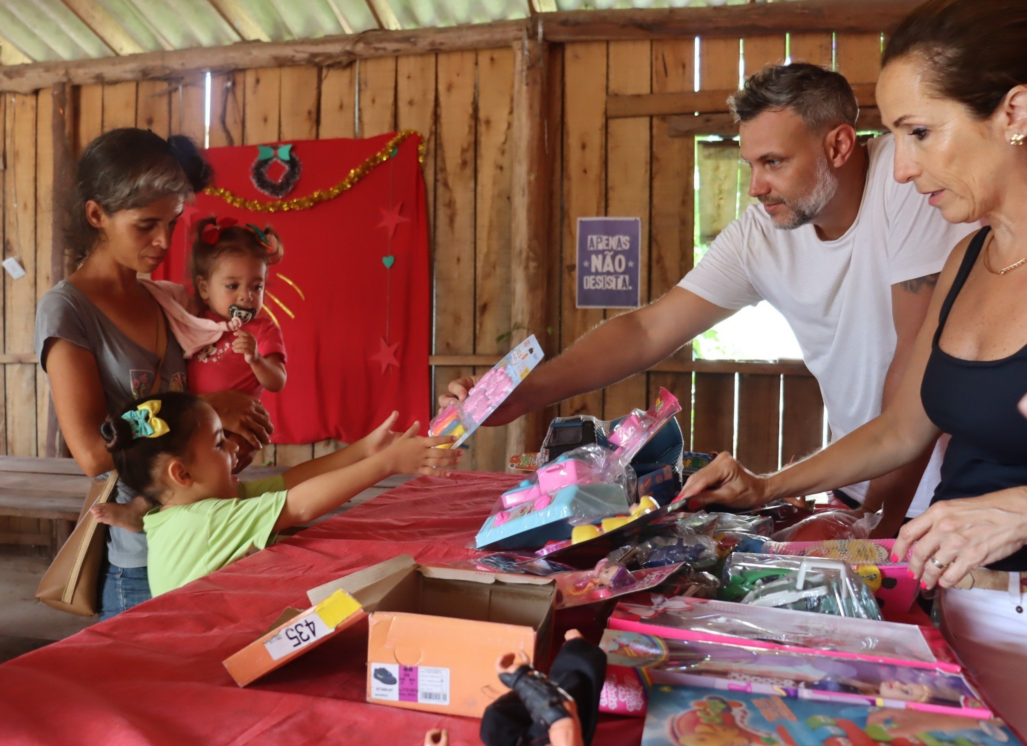 Entrega de brinquedos do projeto Melodia SolidÃ¡ria na OcupaÃ§Ã£o Steigleder - Emanuelle, 5 anos, recebendo a massinha de modelar