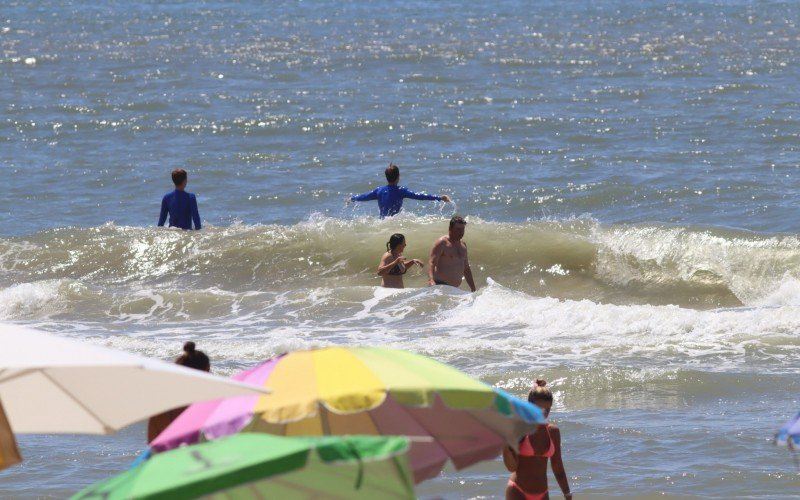 Mar claro atrai turistas para a beira da praia