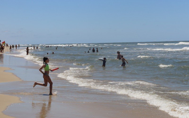 Mar claro atrai turistas para a beira da praia