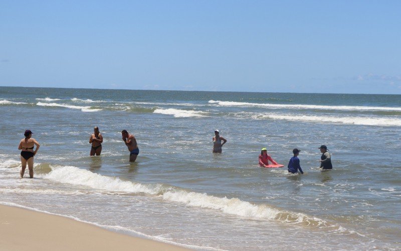 Mar claro atrai turistas para a beira da praia