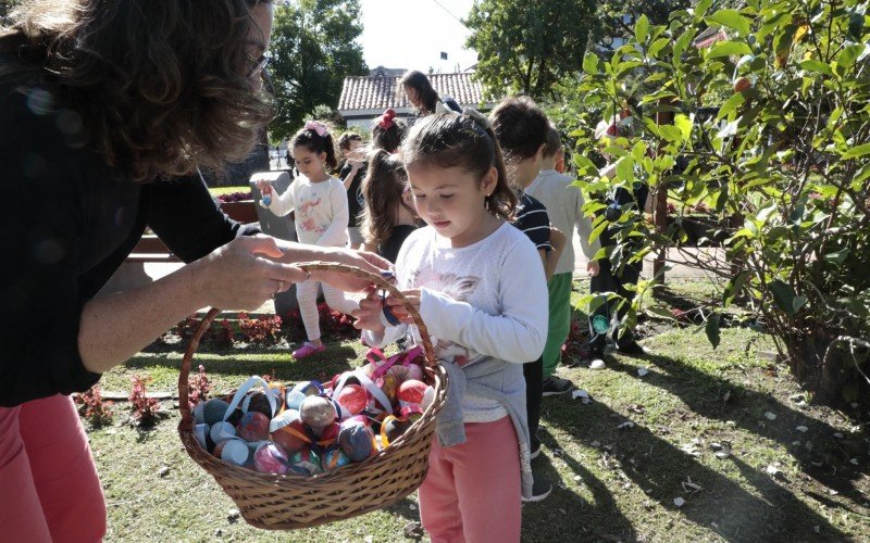 Crianças enfeitam árvores na Vila de Páscoa 