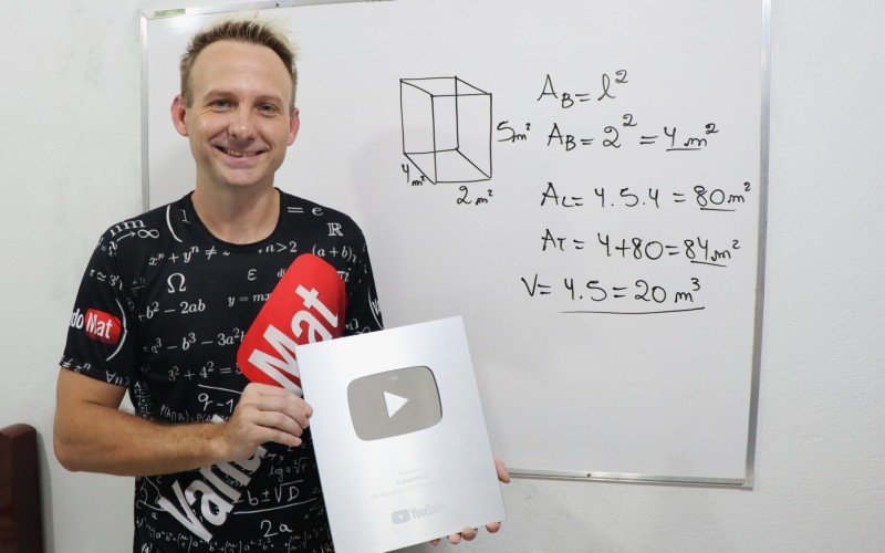 Professor exibe orgulhoso sua placa de 100 mil inscritos no YouTube
