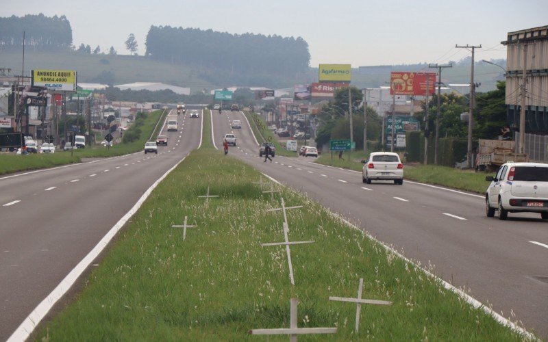 Pedestres se arriscam a atravessar rodovia em trecho onde moradores colocaram mais de 10 cruzes e uma faixa implorando o fim das mortes na 239