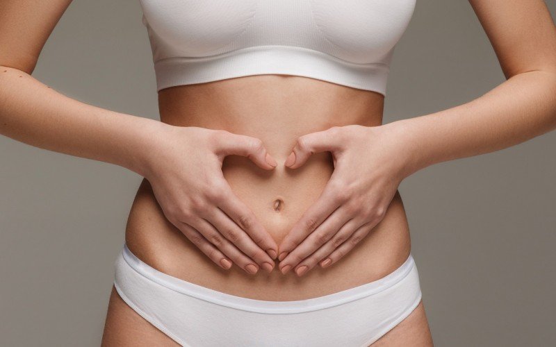 útero ovários órgãos reprodutores mulher mulher com mão na barriga | abc+