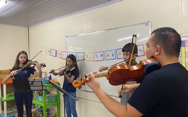 Alunos aprendem a tocar instrumentos como o violino