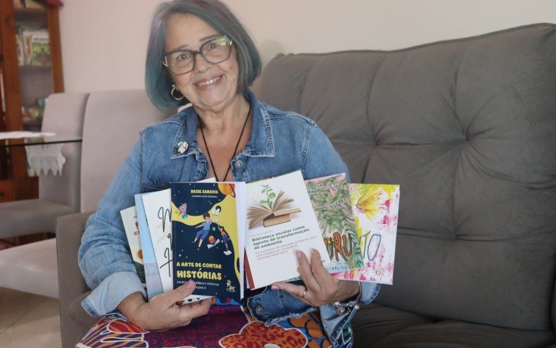 Vera com os livros que já escreveu e participou; na mão esquerda, os de literatura infantil 