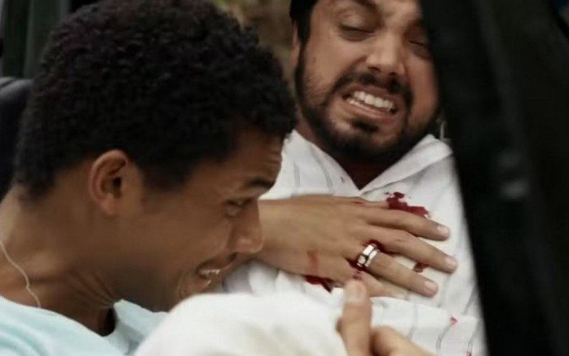 João Pedro (Juan Paiva) carrega José Venâncio (Rodrigo Simas) após tiro, em Renascer   | abc+