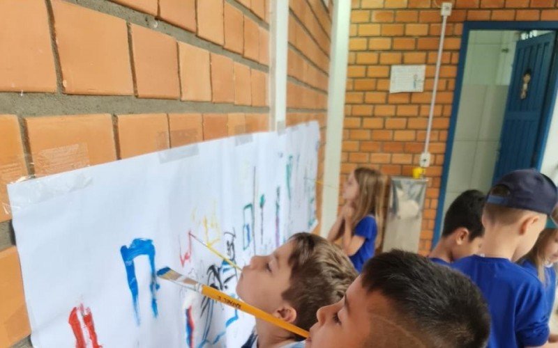 Alunos do 1º Ano da Emeb Cecília Meireles, de Novo Hamburgo, fazendo a experiência de pintar com a boca assim como o artista plástico Marcelo Cunha | abc+