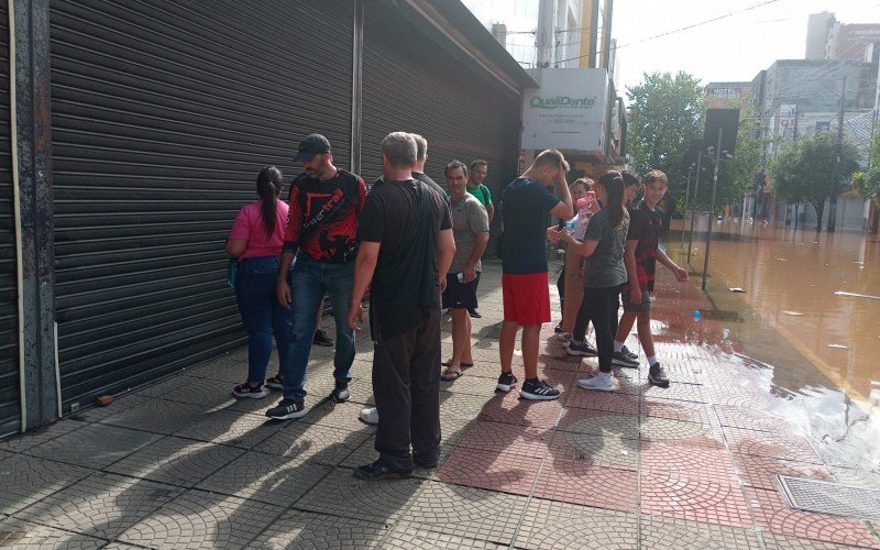 Lojistas tentam salvar mercadorias enquanto água sobe na Rua Independência