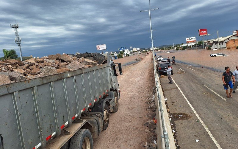 Na tarde desta quarta-feira (8), caminhões caçamba seguiam carregando cargas de rachão (pedras) para o local 