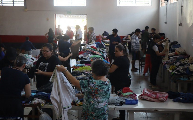 Voluntários separam roupas para doações