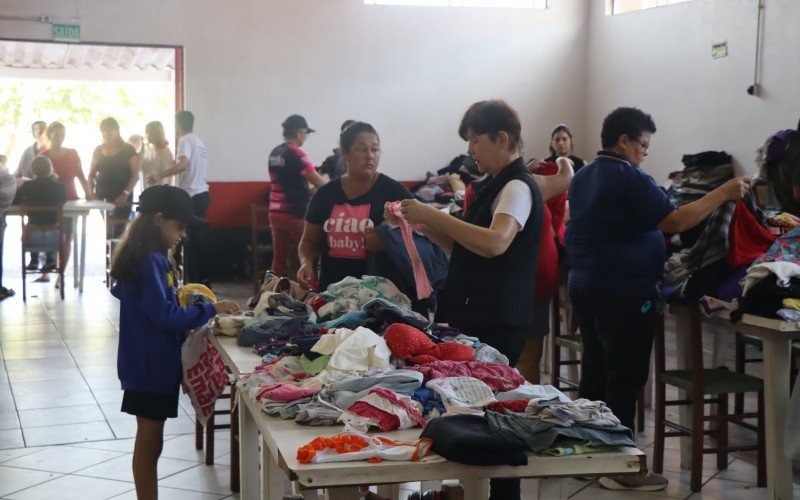 Voluntários separam roupas para doações