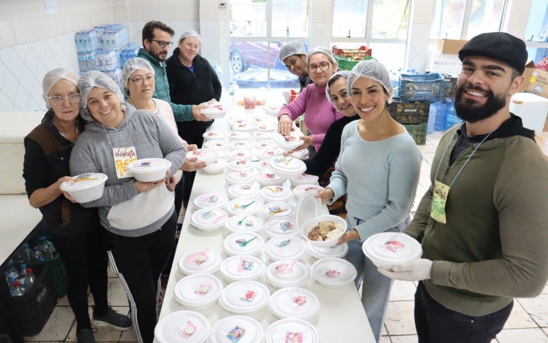 Voluntários mostram marmitas preparadas para a hora do almoço no abrigo da Escola Gusmão Britto