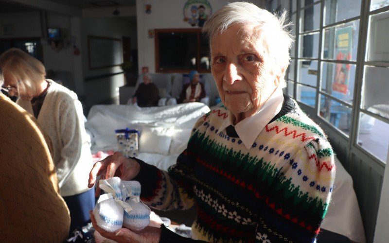 Silvia mostra os sapatinhos de tricot que ela mesma fez