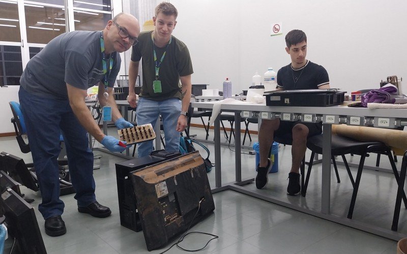  O professor de Engenharia Eletrônica, Paulo Ricardo Viana, com os alunos Gabriel Gaudert e Cauê Ryan Puntel Lampert, no conserto de equipamentos na Feevale  | abc+