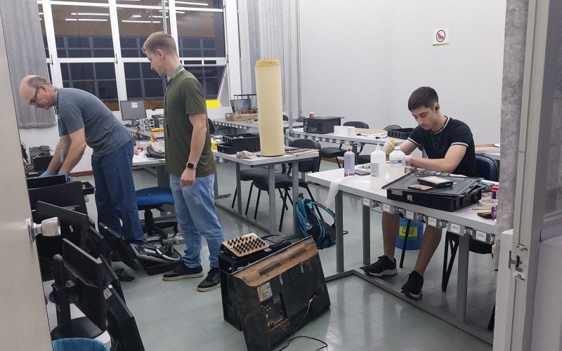  O professor de Engenharia Eletrônica, Paulo Ricardo Viana, com os alunos Gabriel Gaudert e Cauê Ryan Puntel Lampert, no conserto de equipamentos na Feevale  | abc+