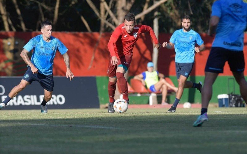 Atleta da Lusa conduz a bola entre três jogadores gremistas | abc+