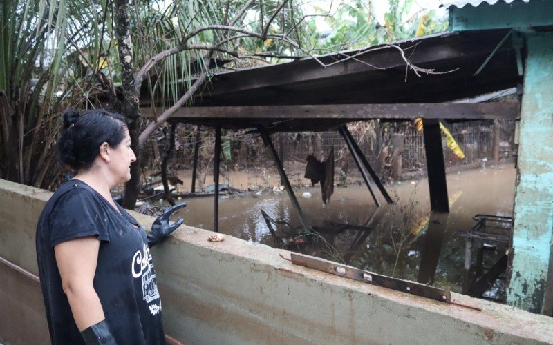 Clarice observa, com medo, a água ainda tomando conta no pátio da vizinha