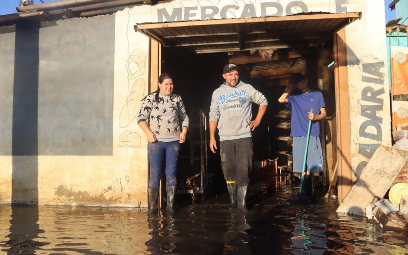 Moradores tentam fazer a limpeza em meio à água escura | abc+