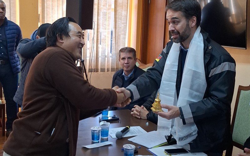 Momento em que o empresário Ogyen Shak entrega a Estupa (escultura) e a Katag (lenço branco) ao governador 