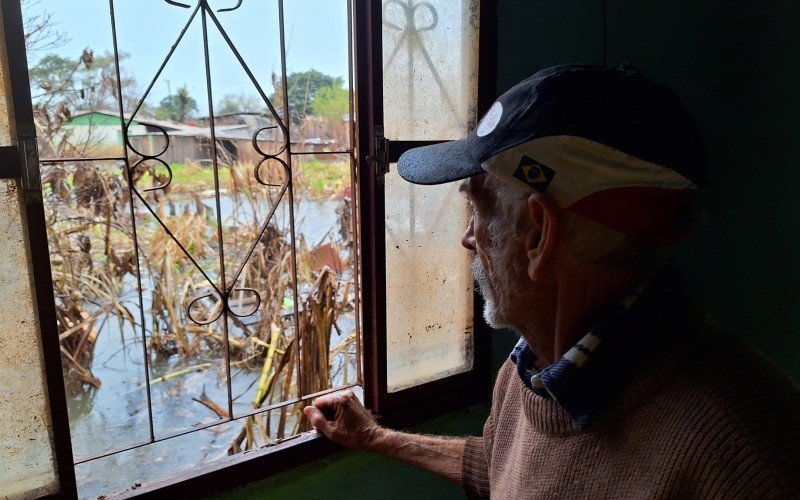 O aposentado Maurício Belizário da Silva, 69 anos, continua com água no pátio dos fundos de casa