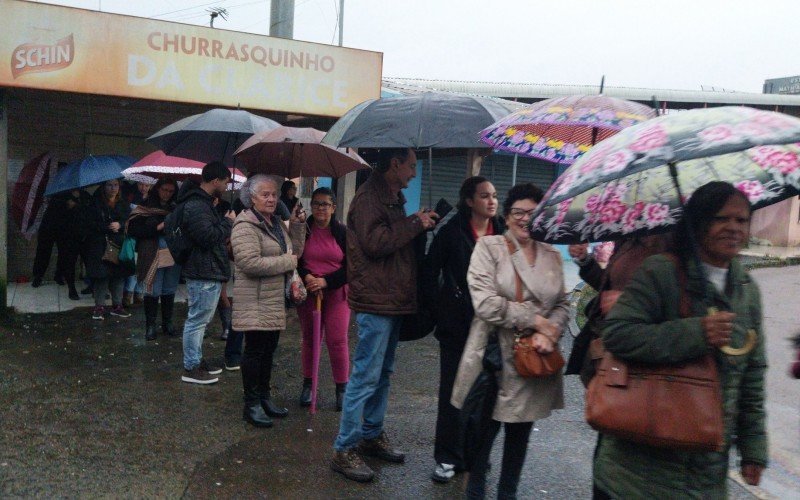 Usuários aguardam na chuva para embarcar em ônibus da Transcal