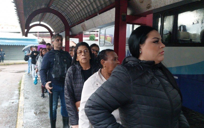 Usuários aguardam na chuva para embarcar em ônibus da Transcal