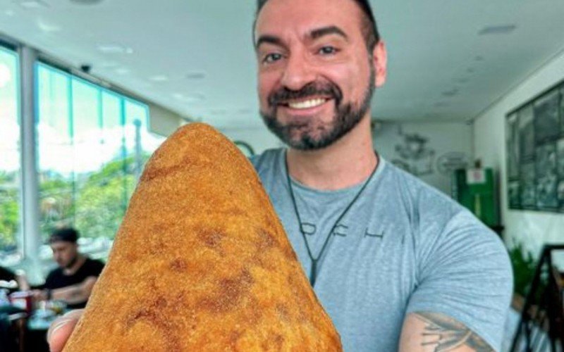 Ricardo Corbucci com uma coxinha gigante; youtuber brasileiro encarou o desafio do cachorro-quente nos EUA | abc+